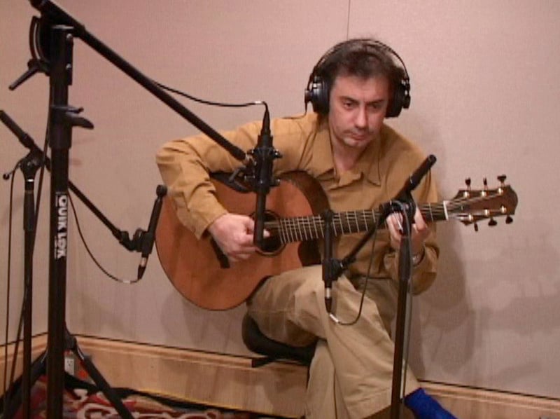 Pierre Bensusan playing acoustic guitar in front of an SF-24 and two small diaphragm condensers