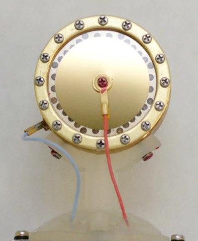 A condenser microphone capsule, showing the thin membrane mounted over the backplate